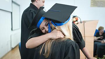 Graduation Two young women embrace to celebrate their graduation.
